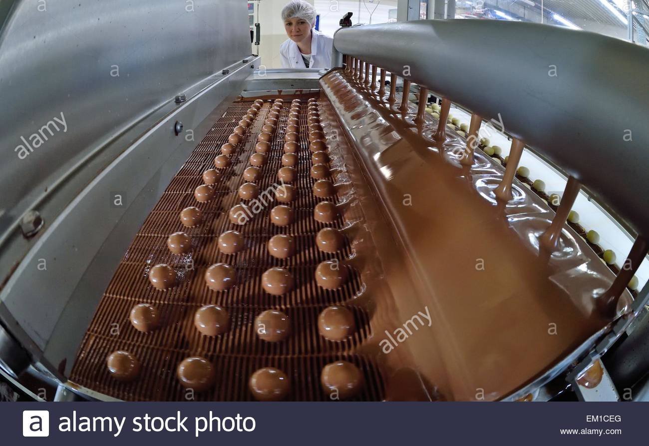 Производит сладости. Новосибирская шоколадная фабрика конвейер. Производство шоколада конвейер. Формовка шоколада. Конвейер на конфетной фабрике.