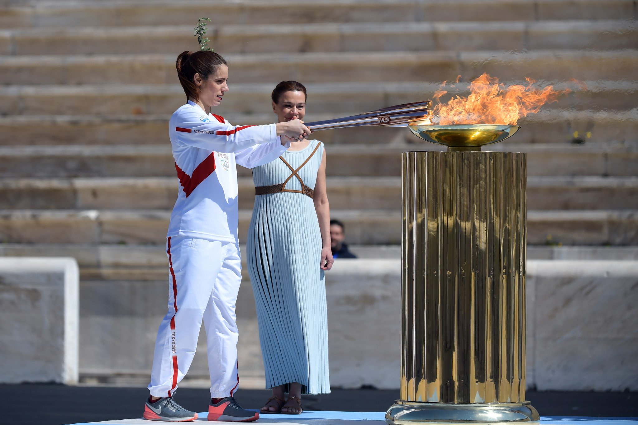 Факел современные игры зажигается. Зажжение олимпийского огня. Церемония зажжения олимпийского огня в Греции. Церемония зажжения олимпийского огня 2020. Олимпийский огонь Токио 2020.